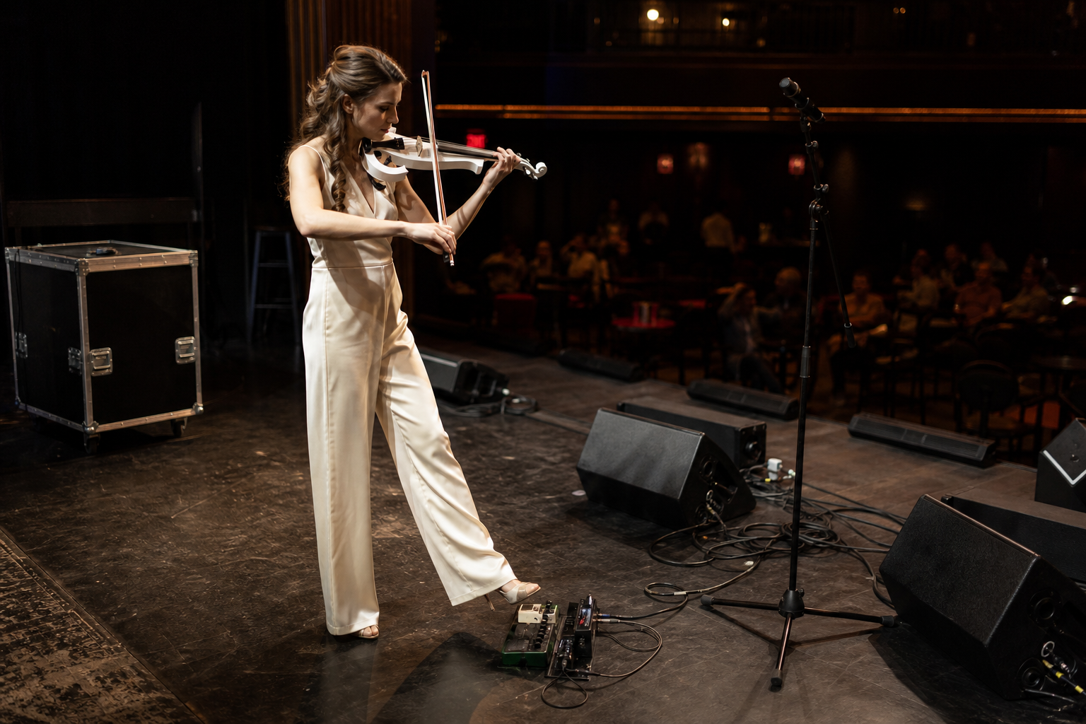 Electric violin изпълнителка на сцена по време на soundcheck с крак близо до clean boost педал и подготвени wedge монитори