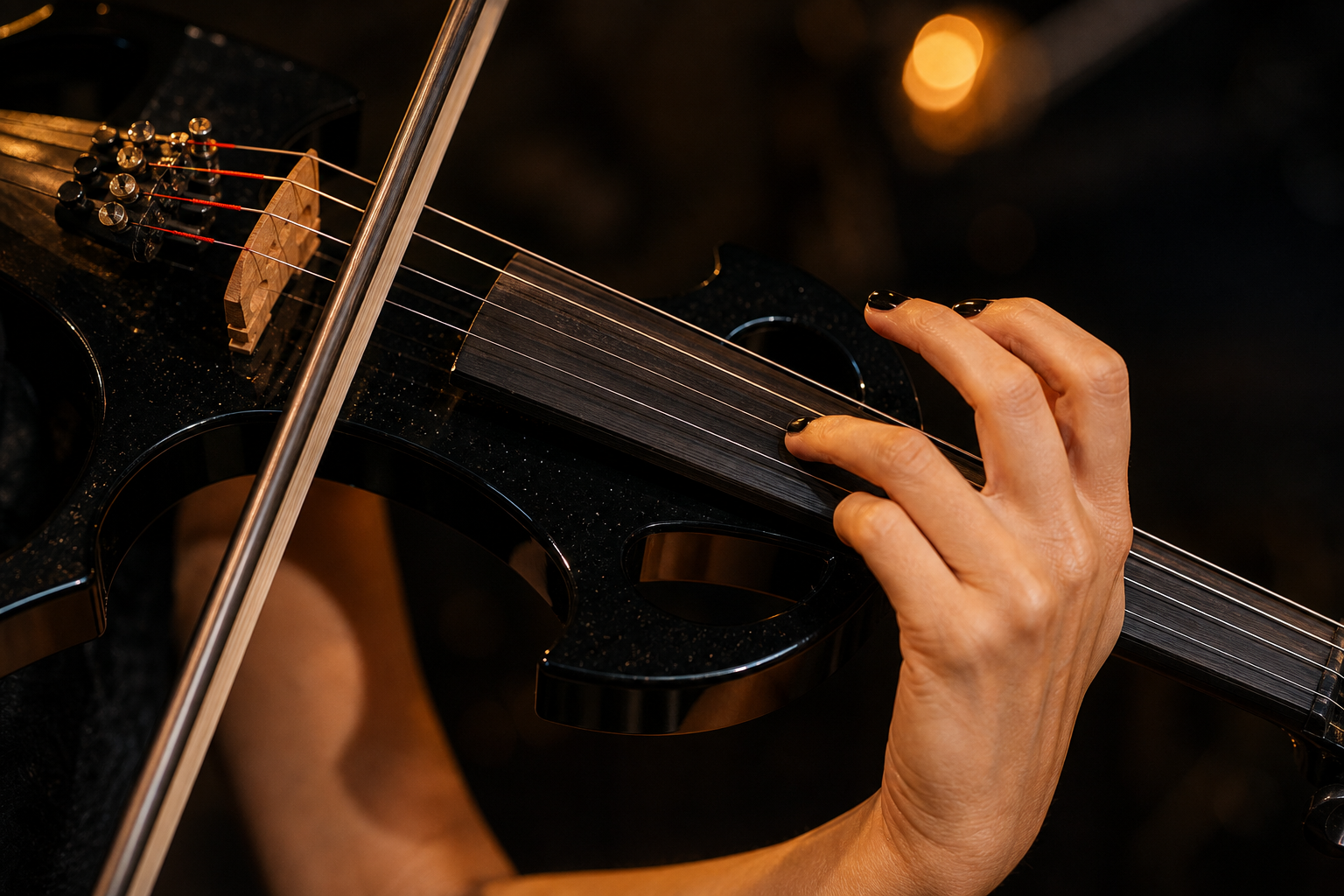 Близък кадър на лява ръка върху грифа на черна electric violin цигулка, докато лъкът свири близо до магарето