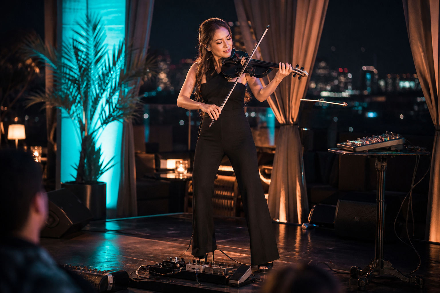 Electric violin изпълнител на стилна rooftop сцена използва octave и pitch педали, за да направи solo live сета по-голям